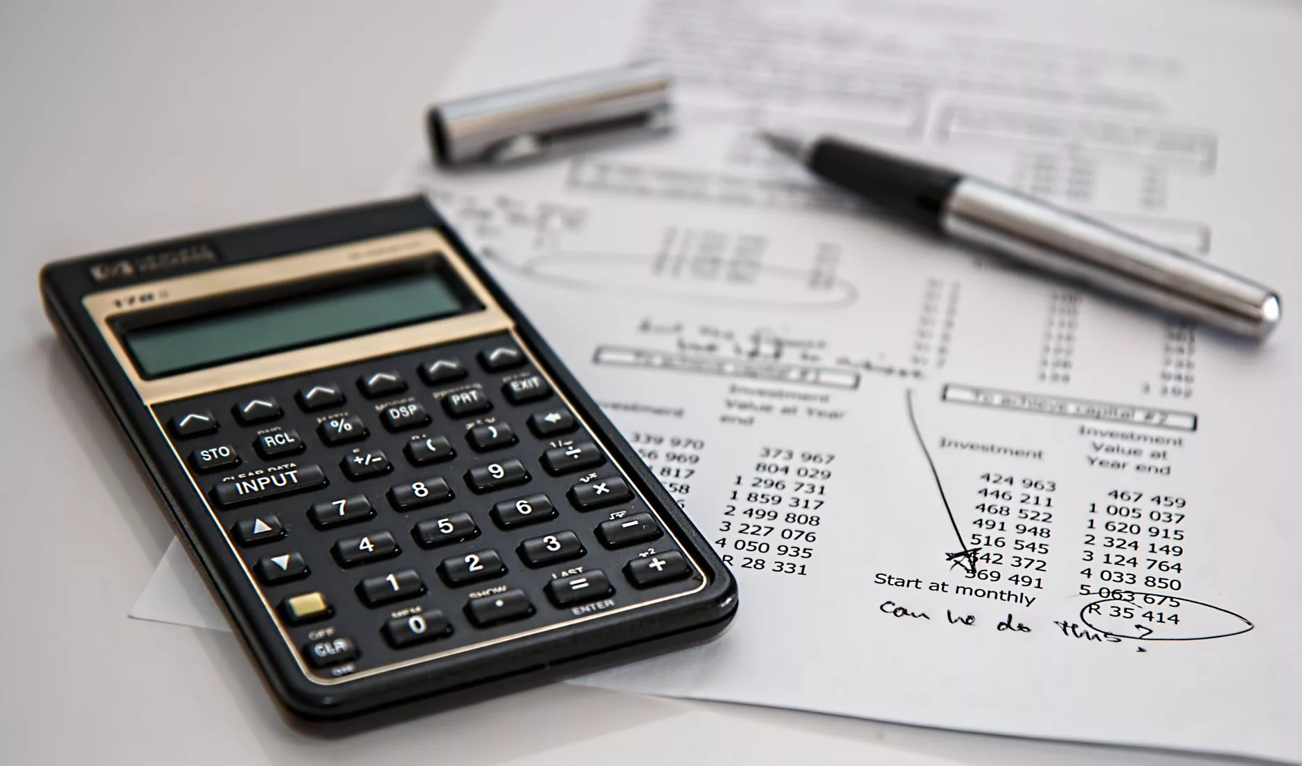 hands calculating surrogacy budget on a tablet with medical bills nearby