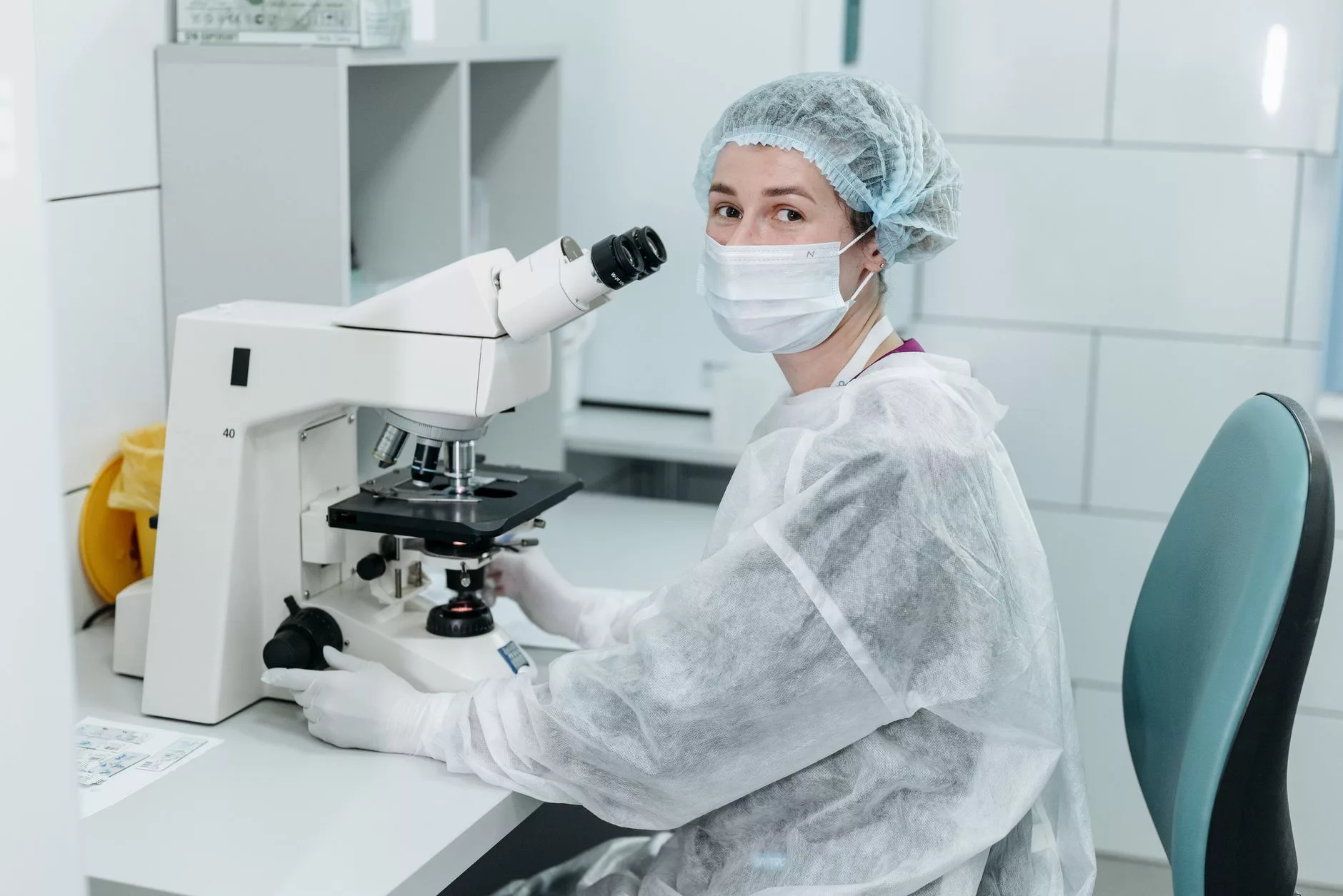 Core Genetic Testing and Carrier Screening in Egg Donor Selection a laboratory worker examining microscopic slides under advanced lighting
