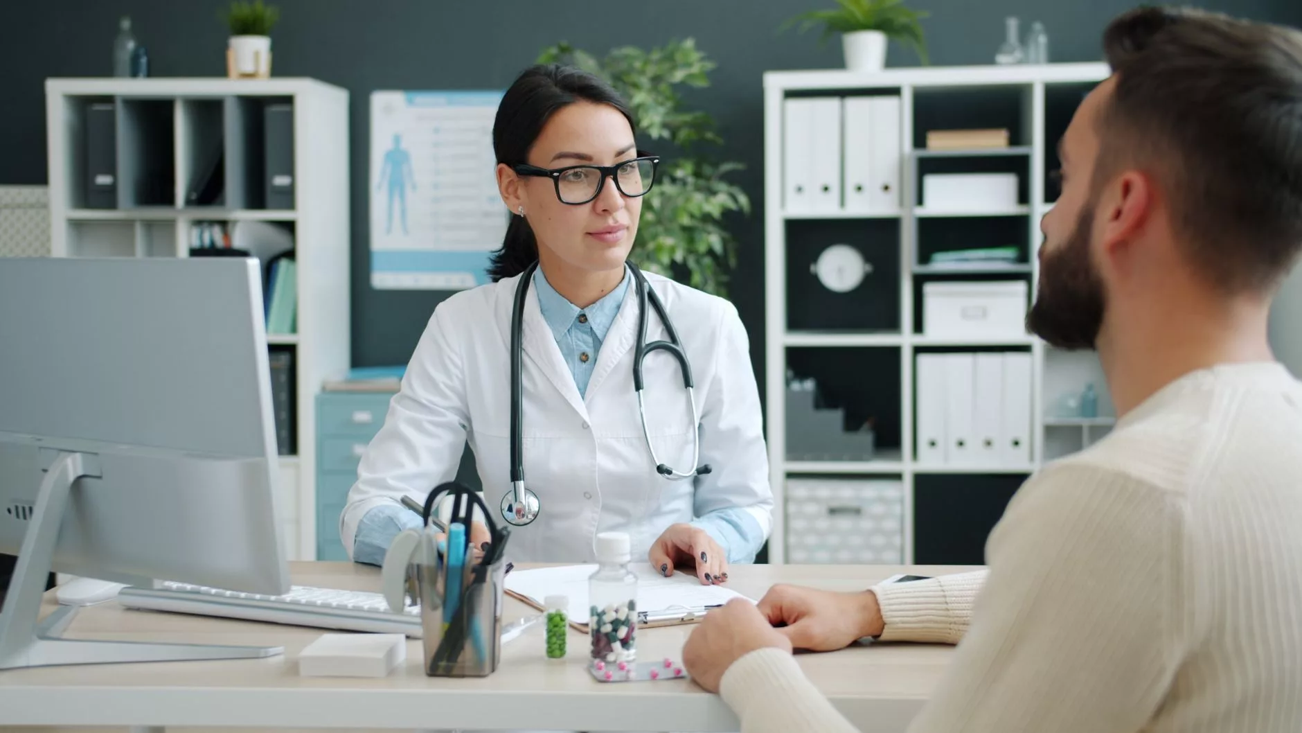 The Evolution of Donor Selection and Medical Screening Standards a doctor reviewing medical history files with a patient in a bright consultation room